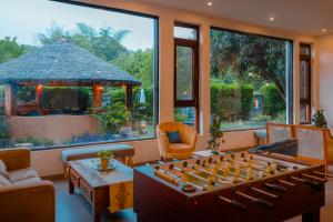 a living room with a large game board in front of a large window at Tree of Life Vanvilas Riveredge Corbett in Rāmnagar