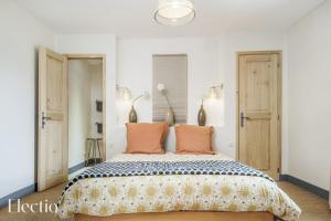リュストレルにあるParenthèse en Luberonのベッドルーム1室(大型ベッド1台、オレンジ色の枕付)