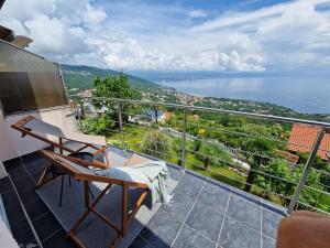 a balcony with a chair and a view of the water at Ferienwohnung mit 180° Meerblick (nähe Opatija) in Dobreć