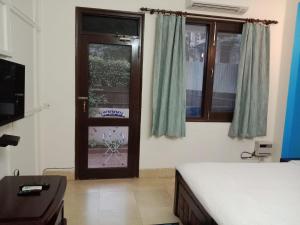 Habitación con cama y puerta con ventana en BedChambers Serviced Apartments, Sushant Lok, en Gurgaon
