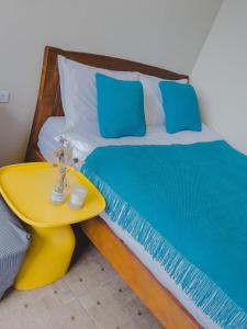 un letto con un tavolino giallo accanto di 炎島 & 莎蔓民宿Salman a Green Island