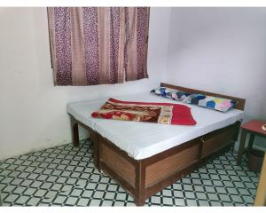 een klein bed in een kamer met een raam bij Hotel Jagatguru, Barkot in Barkot