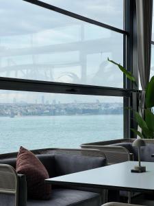 Pera Bosphorus Hotel في إسطنبول: غرفة مع نافذة كبيرة مطلة على الماء