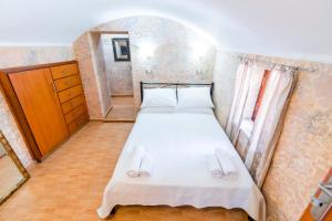 a small bedroom with a bed with slippers on it at EIRINI in Symi