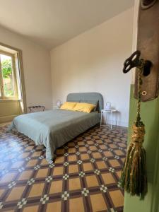 een slaapkamer met een bed en een geruite vloer bij Villa Pia Lena in Magreglio