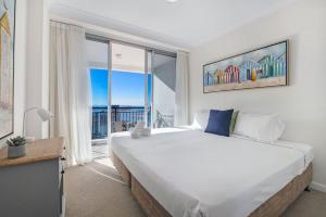 een slaapkamer met een groot bed en een groot raam bij Ocean Views Apartment in Southport Central in Gold Coast