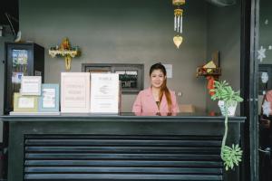 a woman standing behind the counter of a restaurant at Noble House Patong in Patong Beach