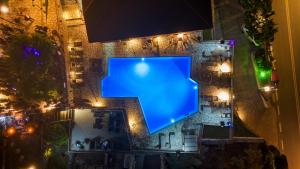 a blue pool in the middle of a building at night at Semiramis in Lefkada Town