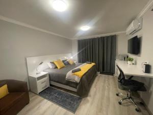 1 dormitorio con cama, escritorio y ordenador en De Tuin Accommodation en Ciudad del Cabo