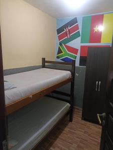 Zimmer mit 2 Etagenbetten und einer Wand mit Flaggen in der Unterkunft Hostel Morais Praia in Maceió