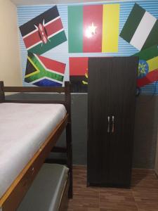a room with a bed and a cabinet with flags on the wall at Hostel Morais Praia in Maceió