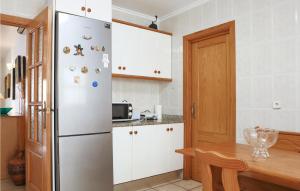 a kitchen with a refrigerator and a wooden table at Gorgeous Home In Pilar De La Horadada in Pilar de la Horadada