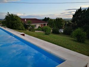 una piscina blu in un cortile con una casa di B&B Villa Lena a Turi