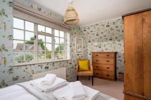 a bedroom with a bed and a dresser and a window at Pats' Place Long Melford in Sudbury