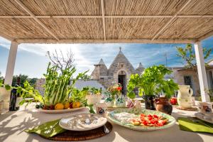 a table with plates of food and a building in the background at Trullo Nostress with pool in Ceglie Messapica