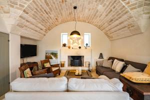 a living room with two couches and a fireplace at Trullo Nostress with pool in Ceglie Messapica