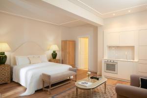 una camera con letto bianco e un soggiorno di Old Town Luxury Suites Acropolis ad Atene