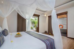 a bedroom with a white bed with a canopy at Reswaha Villas by Pramana Villas in Ubud