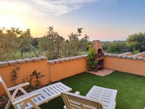 un patio con 2 sedie e un cortile con prato di Casa Vacanza Sardegna a Valledoria