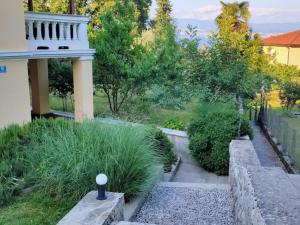 - une vue sur le jardin du côté d'une maison dans l'établissement Apartment Hermes, à Lovran