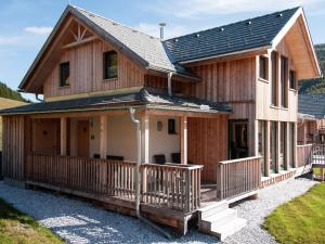 ein großes Holzhaus mit einer Veranda in der Unterkunft Chalet in Hohentauern Styria with sauna in Hohentauern