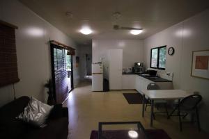 a living room with a table and a kitchen at Family Friendly in Howard Springs