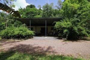 a building with a canopy in the middle of trees at Family Friendly in Howard Springs