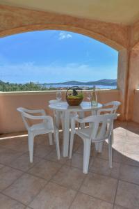 a white table and chairs with a view of the ocean at La Costa View in Arzachena