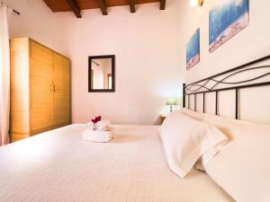 1 dormitorio con 1 cama blanca grande y 2 toallas en En plena naturaleza a 800m Playa Migjorn en Playa de Migjorn