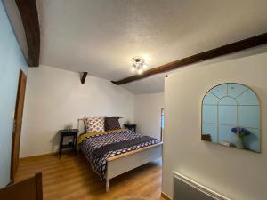 1 dormitorio con cama y espejo en la pared en Au Bien Hêtre, en Futeau
