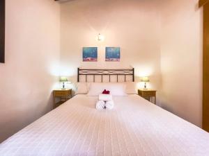a bedroom with a large white bed with two night stands at En plena naturaleza a 800m Playa Migjorn in Playa Migjorn
