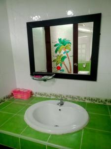 a bathroom with a white sink and a mirror at บ้านนารีสอร์ท in Nakhon Nayok
