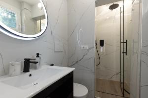 Un baño blanco con lavabo y ducha. en Station Apartment, en Pisa