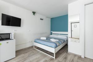 Un dormitorio con una cama y un televisor de pantalla plana. en Station Apartment, en Pisa