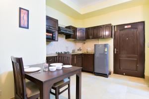 eine Küche mit einem Tisch und einem Kühlschrank in der Unterkunft Studio Serviced Apartments near Fortis Hospital in Gurgaon