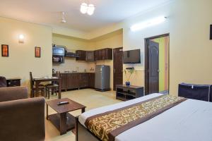 ein Schlafzimmer mit einem Bett und ein Wohnzimmer in der Unterkunft Studio Serviced Apartments near Fortis Hospital in Gurgaon