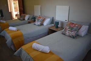 een kamer met drie bedden in een kamer bij Apple Orchard Cottage in Harrismith