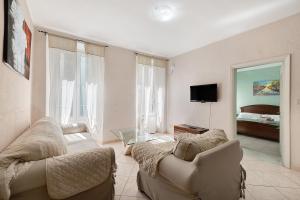 Sala de estar con 2 sofás y TV en Casa Scola Loano, en Loano