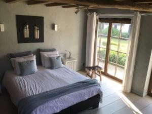 a bedroom with a bed and a large window at Stee 23 in Hertsberge