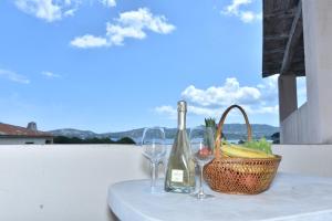 un tavolo con un cesto, una bottiglia di vino e bicchieri di La Costa Mare a Arzachena