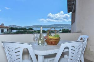 un tavolo con un cesto di banane e bicchieri da vino di La Costa Mare a Arzachena