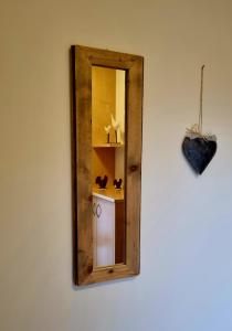 a mirror hanging on a wall with a shelf at Gartnerhof in Plaus