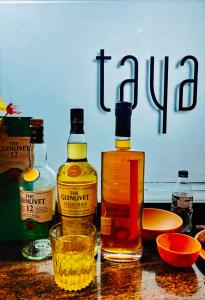 una mesa con dos botellas de alcohol y un vaso en Taya Beach Front, en Gokarna