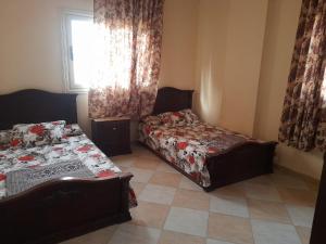 um quarto com 2 camas e uma janela com cortinas em برج قصر السعد خلف فندق الفرسان مباشره em Marsa Matruh