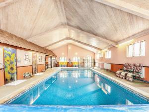 a large swimming pool in a building with a ceiling at Robin Cottage in Temple Combe