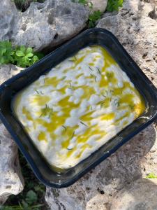 a black dish of food with yellow sauce on rocks at B&B Le Cicale in Vieste