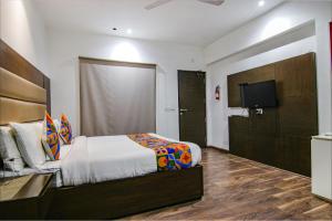 Schlafzimmer mit einem Bett und einem Flachbild-TV in der Unterkunft FabHotel Paradise Ville Resort in Bhīm Tāl
