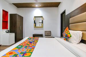 ein Schlafzimmer mit einem großen Bett und einem Spiegel in der Unterkunft FabHotel Paradise Ville Resort in Bhīm Tāl