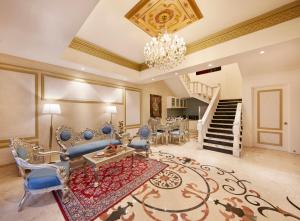 a living room with blue chairs and a chandelier at Kaldan Samudhra Palace in Mahabalipuram