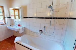 a bathroom with a shower and a tub and a sink at Ferienhaus im modernen Landhauscharme mit Bergblick und Garten in Bischofswiesen
